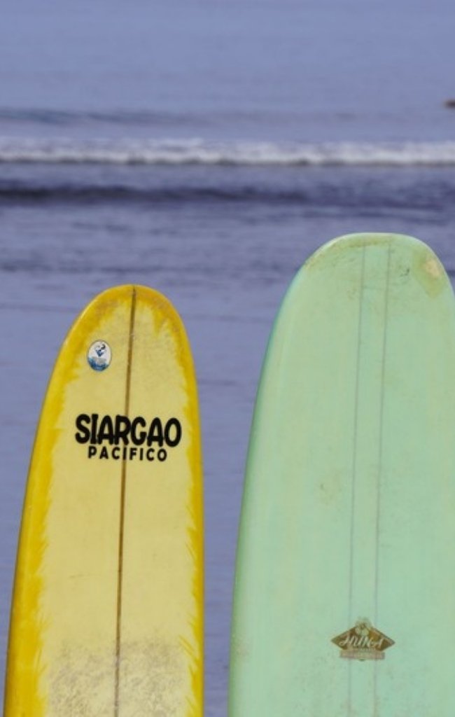 Colorful surfboards lined up on a Siargao beach