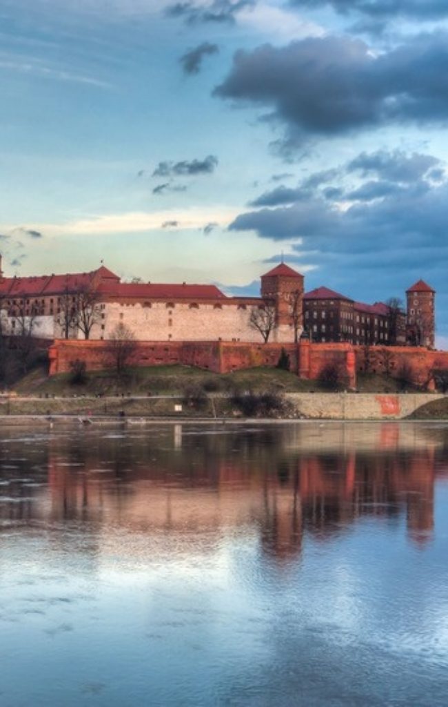 Wawel Castle reflected in the Vistula River at sunset in Krakow