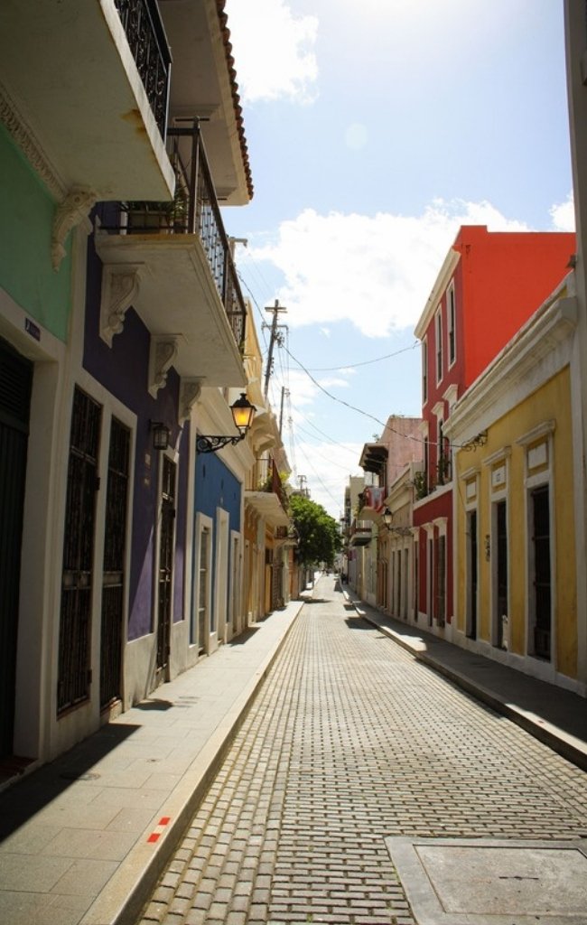 A cobblestone street lined with colorful colonial houses in Old San Juan