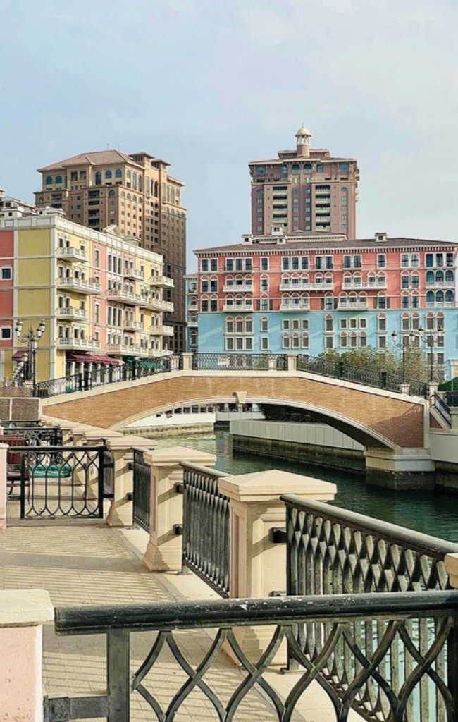 Pastel buildings and a bridge over a canal on The Pearl