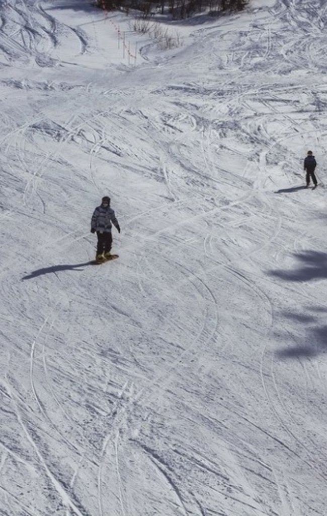 Skiers on a wide, sunny slope