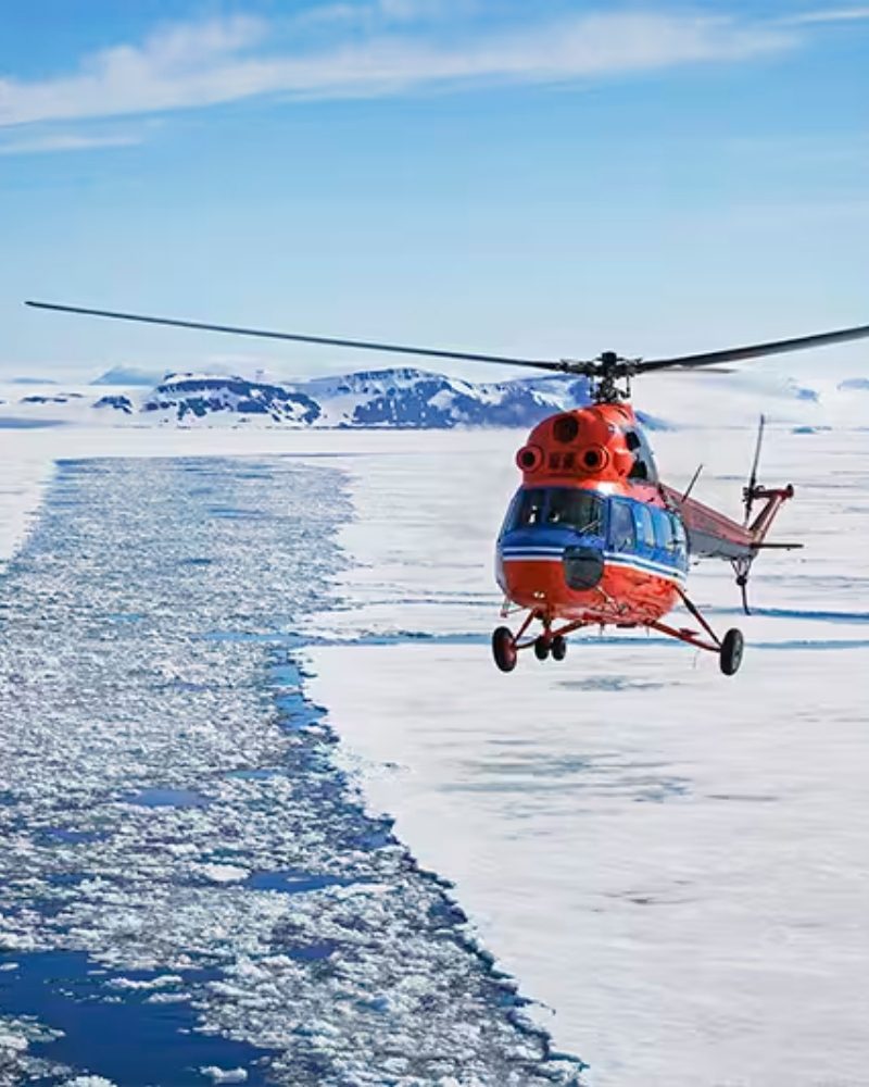 A helicopter flying low over polar sea ice