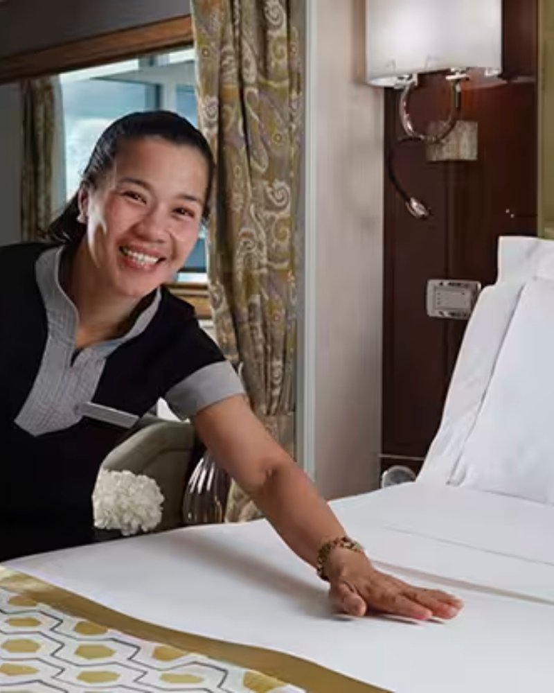 A suite attendant preparing the bed in a Regent suite