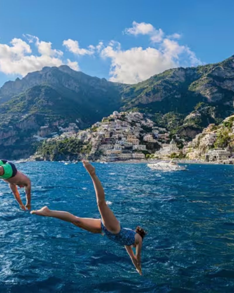 Swimmers diving off a boat near Positano on the Amalfi Coast