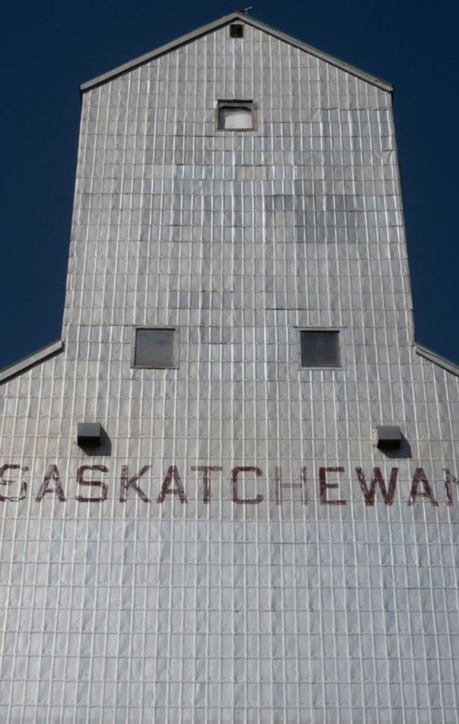 A historic prairie grain elevator against a clear sky