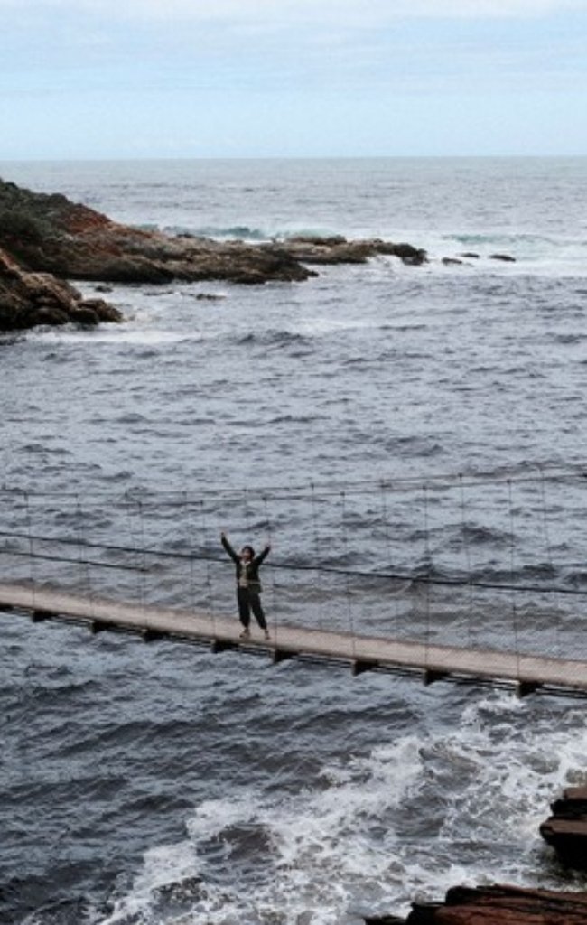A walker on a suspension bridge above the sea on the Garden Route