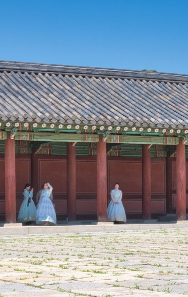 Visitors in hanbok outside a historic palace in Seoul