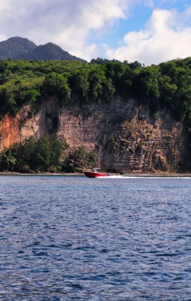 A speedboat along the green cliffs of the St. Lucia coast