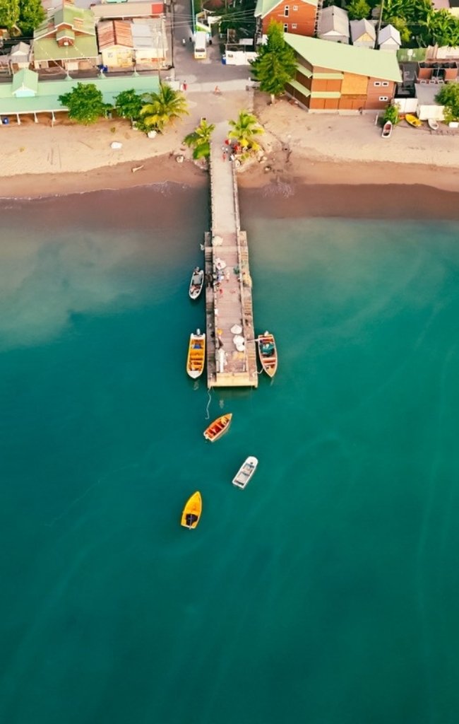 Colorful boats beside a pier in turquoise water