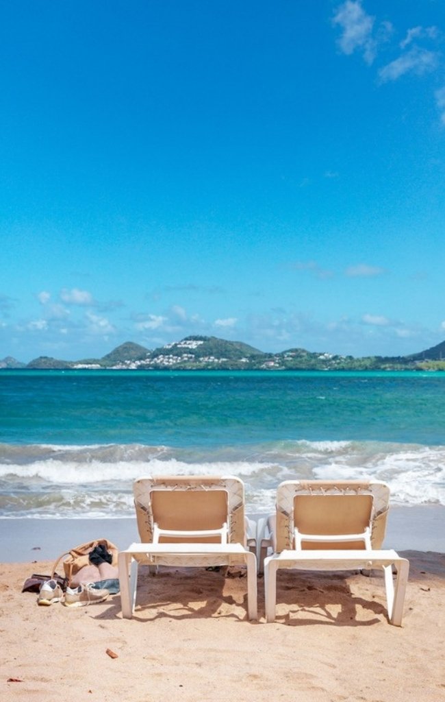 Sun loungers on a beach overlooking Castries