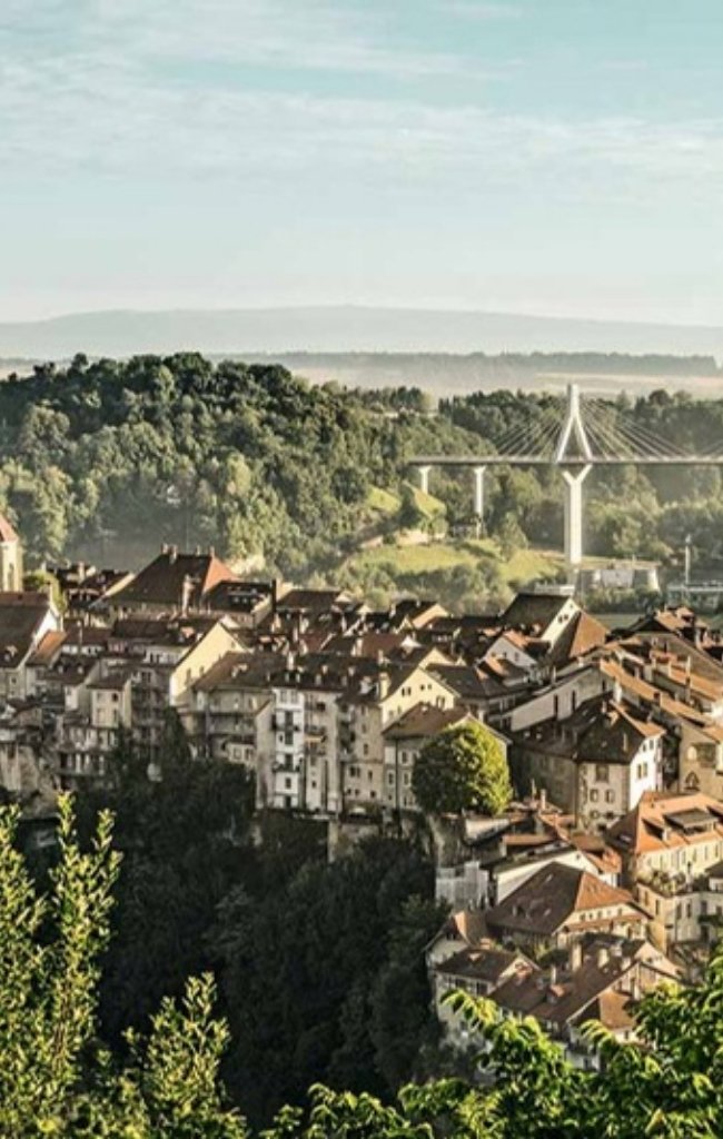 The old town of Fribourg above a wooded river gorge