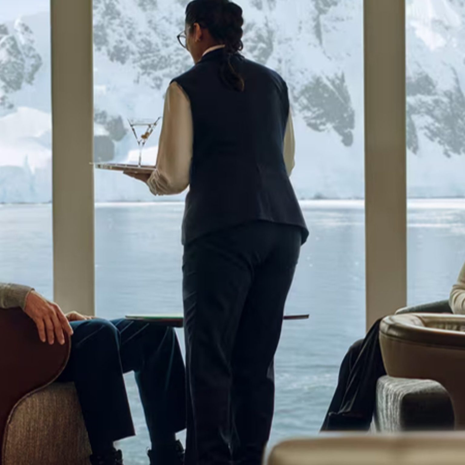 Guests served drinks in an observation lounge facing Antarctic mountains