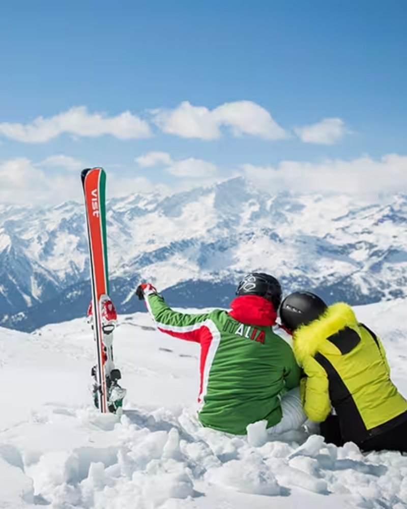 Two skiers resting in the snow above the Alps