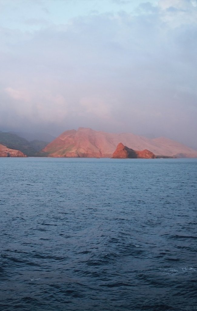 Rugged cliffs of the Marquesas Islands rising from the sea
