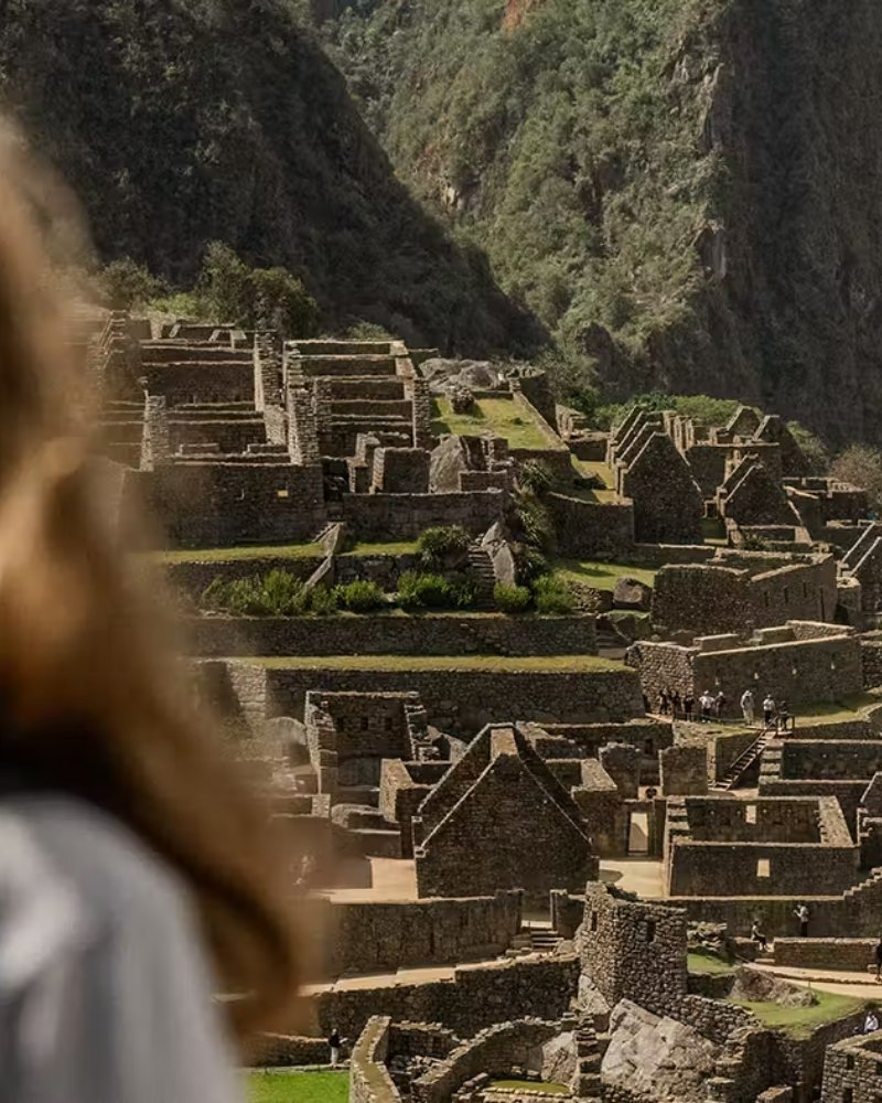 Traveler overlooking the stone terraces of Machu Picchu