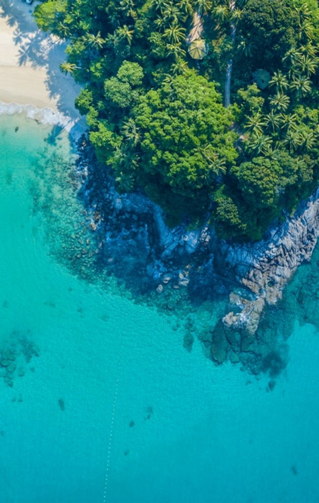 Aerial view of a green headland and turquoise water in Phuket