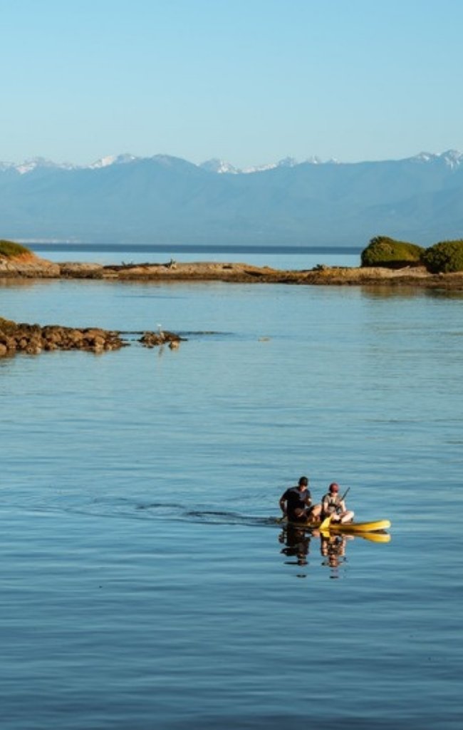 A kayaker paddling between small islands off the British Columbia coast