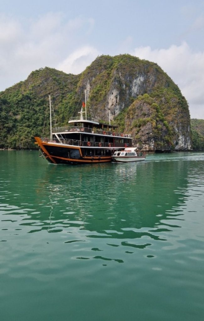 A boat cruising among the islands of Ha Long Bay