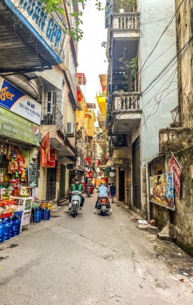 Shops and scooters on a lively street in Hanoi's Old Quarter
