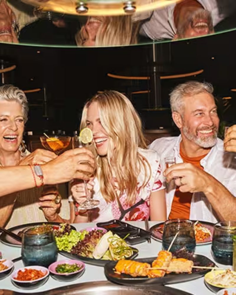 Friends toasting over a Korean barbecue table