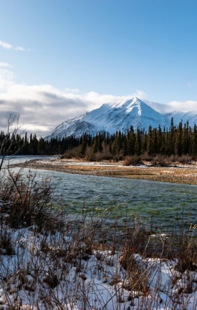 A snowy river below mountains near Haines Junction