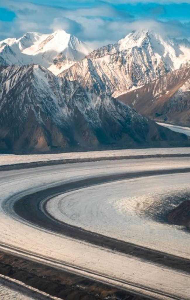 A glacier flowing between snowy peaks in the Kluane icefields