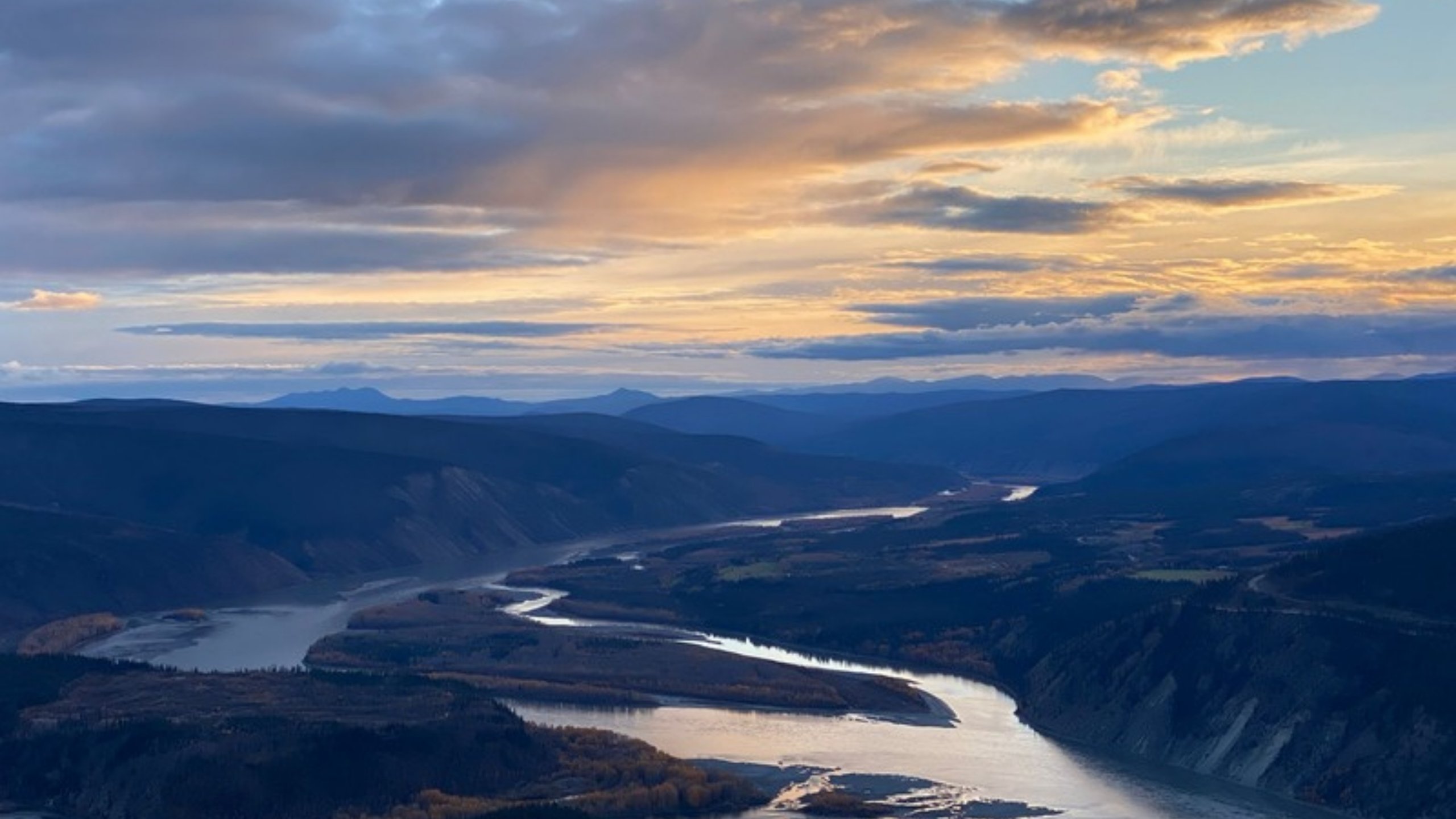 The Yukon River winding through mountains at sunset